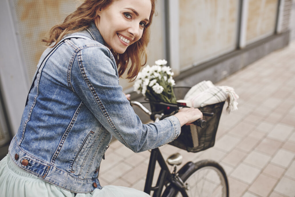 alquiler de bicicletas en valencia - mujer con flores blancas en bici scaled